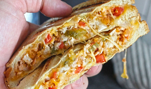Golden toasted sandwich filled with chopped crispy chicken fingers, melted cheese, fresh onions, tomatoes, and pickles.