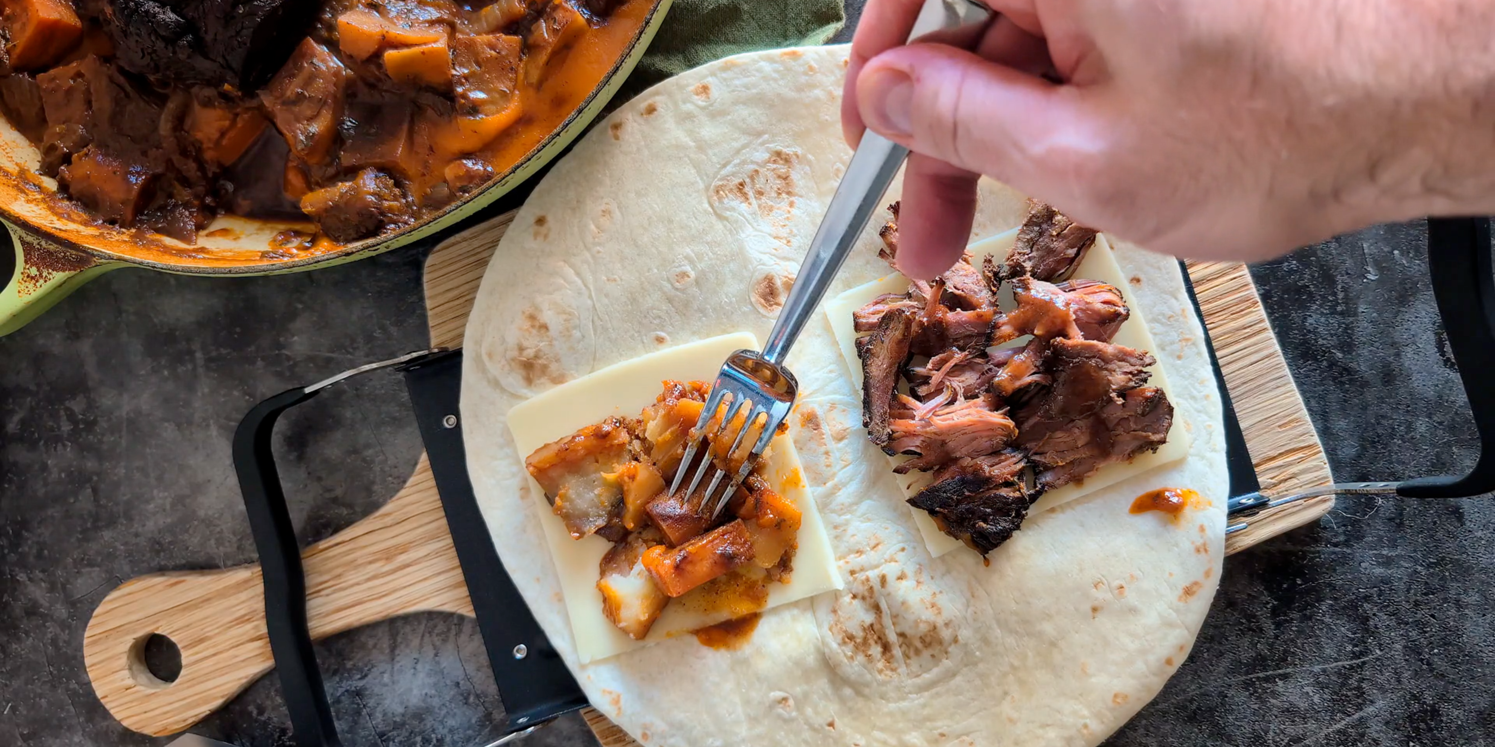 A folded pot roast burrito made in the Revolution Toastie Press™, showing melted cheese, shredded beef, and toasted tortilla.