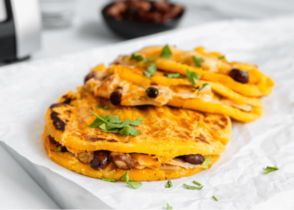 Venezuelan toasted arepa filled with pulled pork, melted cheese, black beans, and green chilis, served with fresh cilantro.