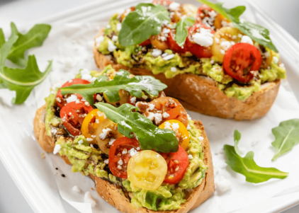 Toasted artisan bread topped with creamy avocado, fresh cherry tomatoes, crumbled feta, arugula, and a drizzle of balsamic glaze.