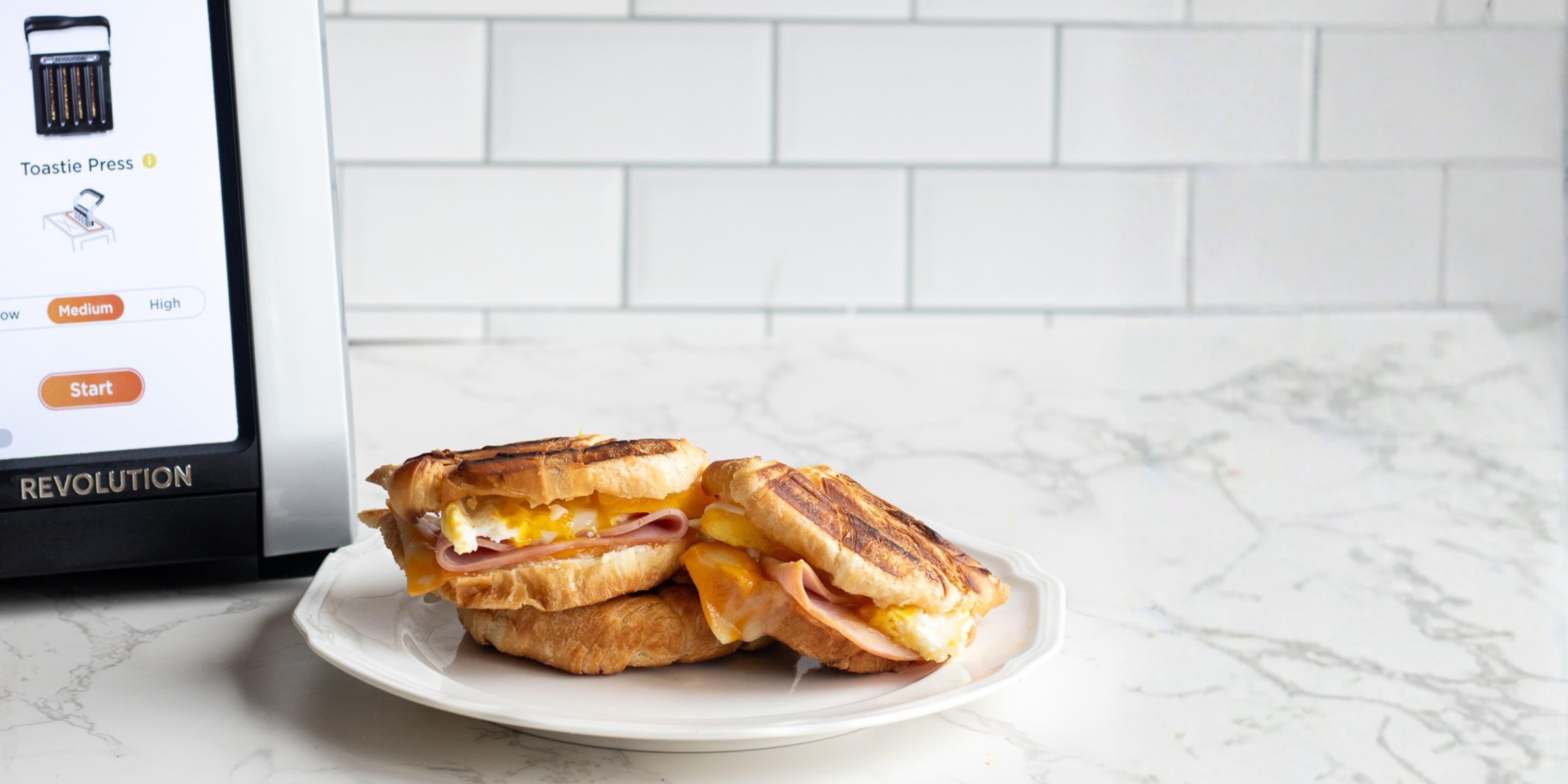 Croissant toastie breakfast sandwich pressed in the toastie press with ham, egg and cheese.