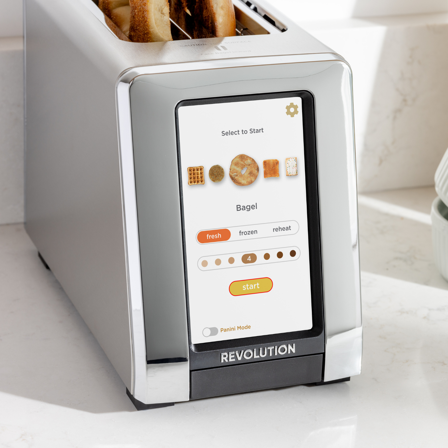 The Renewed R180 Smart Toaster by Revolution Cooking offers a sleek touchscreen for toasting waffles, bagels, and bread. With Panini Mode and an InstaGLO heating system, it guarantees perfect results. Its metallic design adds style to any white kitchen countertop.