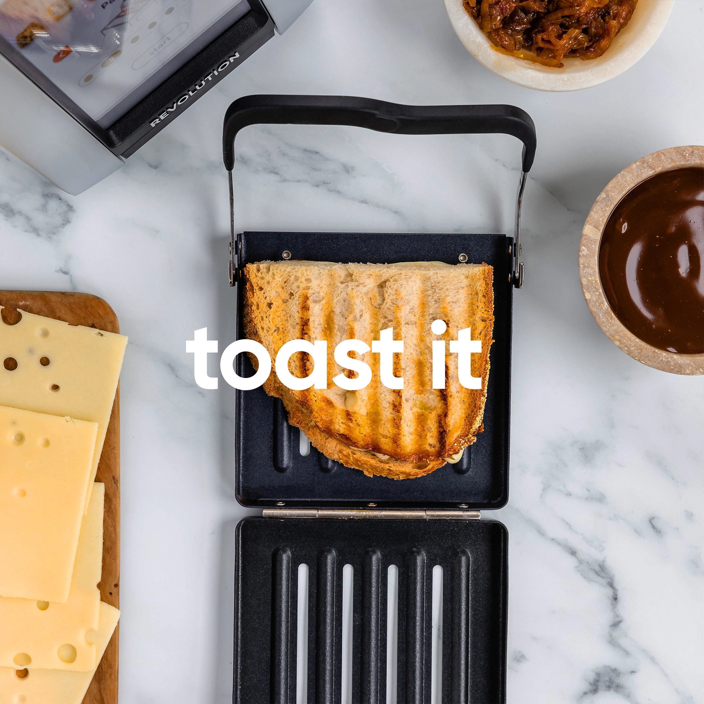 A toasted sandwich on a grill, surrounded by sliced cheese, onions in a bowl, and sauce in another bowl. The text "toast it" is overlaid on the image.
