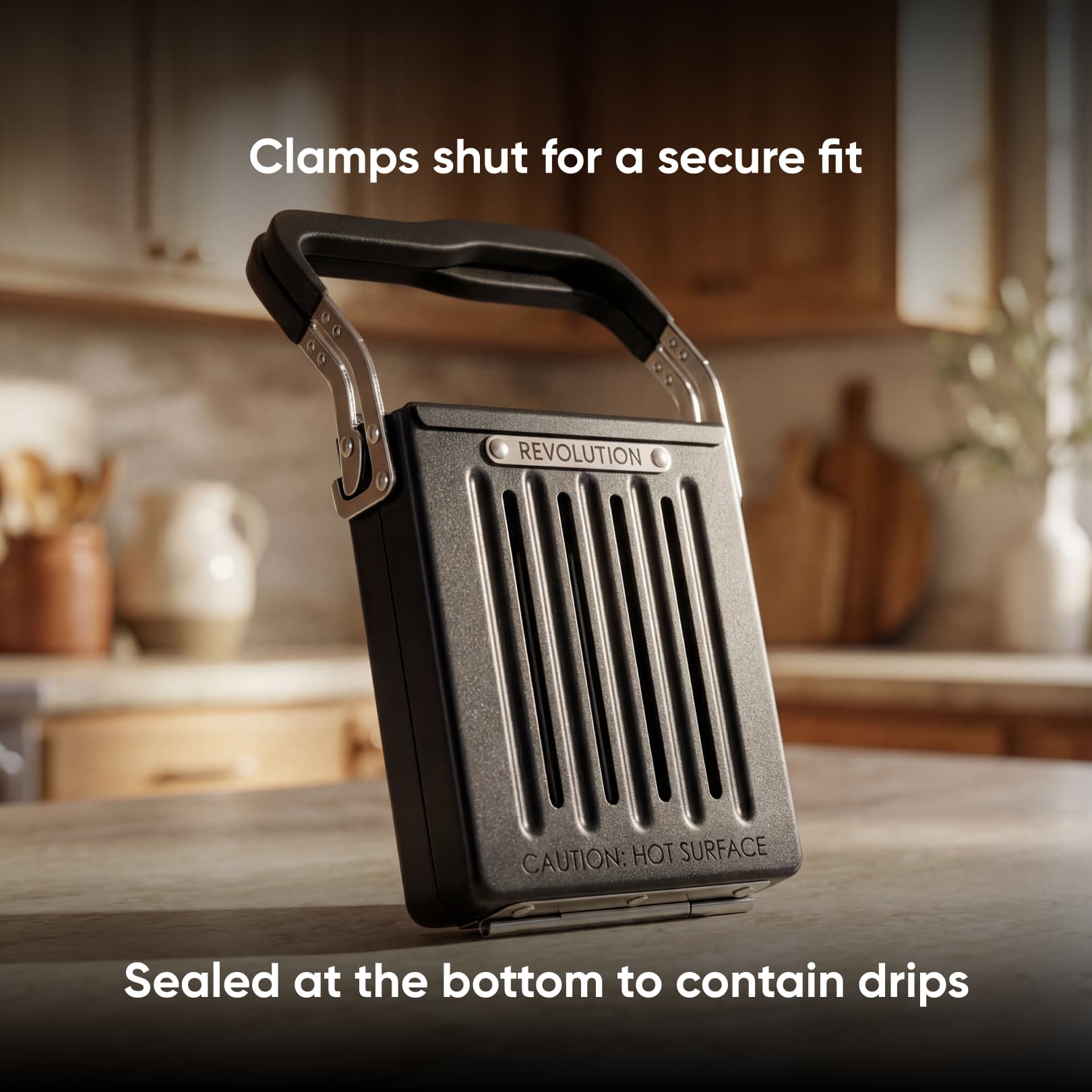 A Revolution Toastie Press by Revolution Cooking with a handle stands upright on a kitchen counter. Text reads: “Clamps shut for a secure fit” and “Sealed at the bottom to contain drips.” The background is softly blurred.