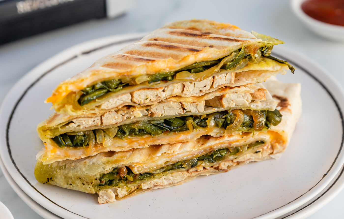 Grilled chicken quesadilla with cheese, onions, and poblano peppers toasted golden in the Revolution Toastie Press™
