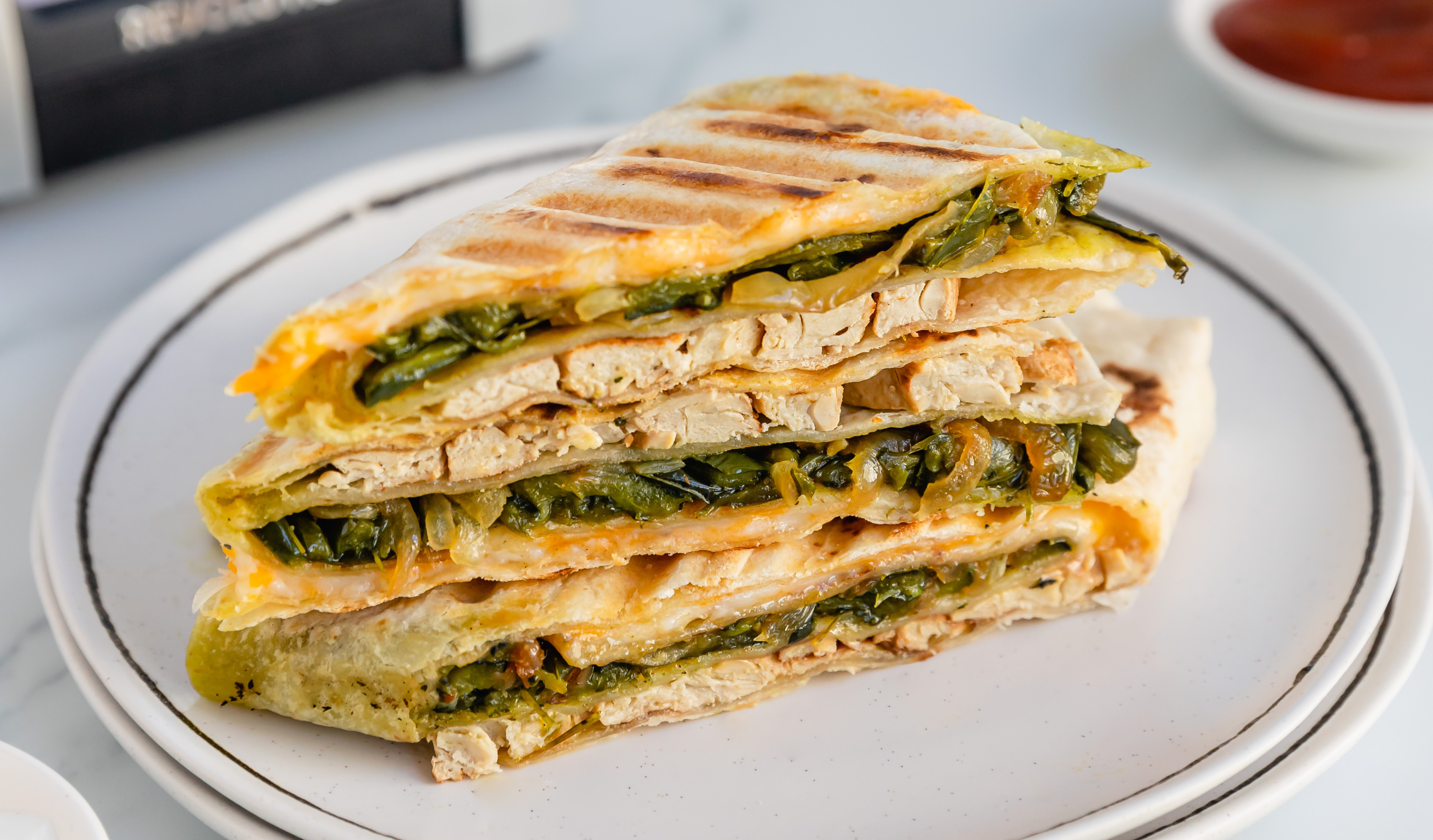 Grilled chicken quesadilla with cheese, onions, and poblano peppers toasted golden in the Revolution Toastie Press™