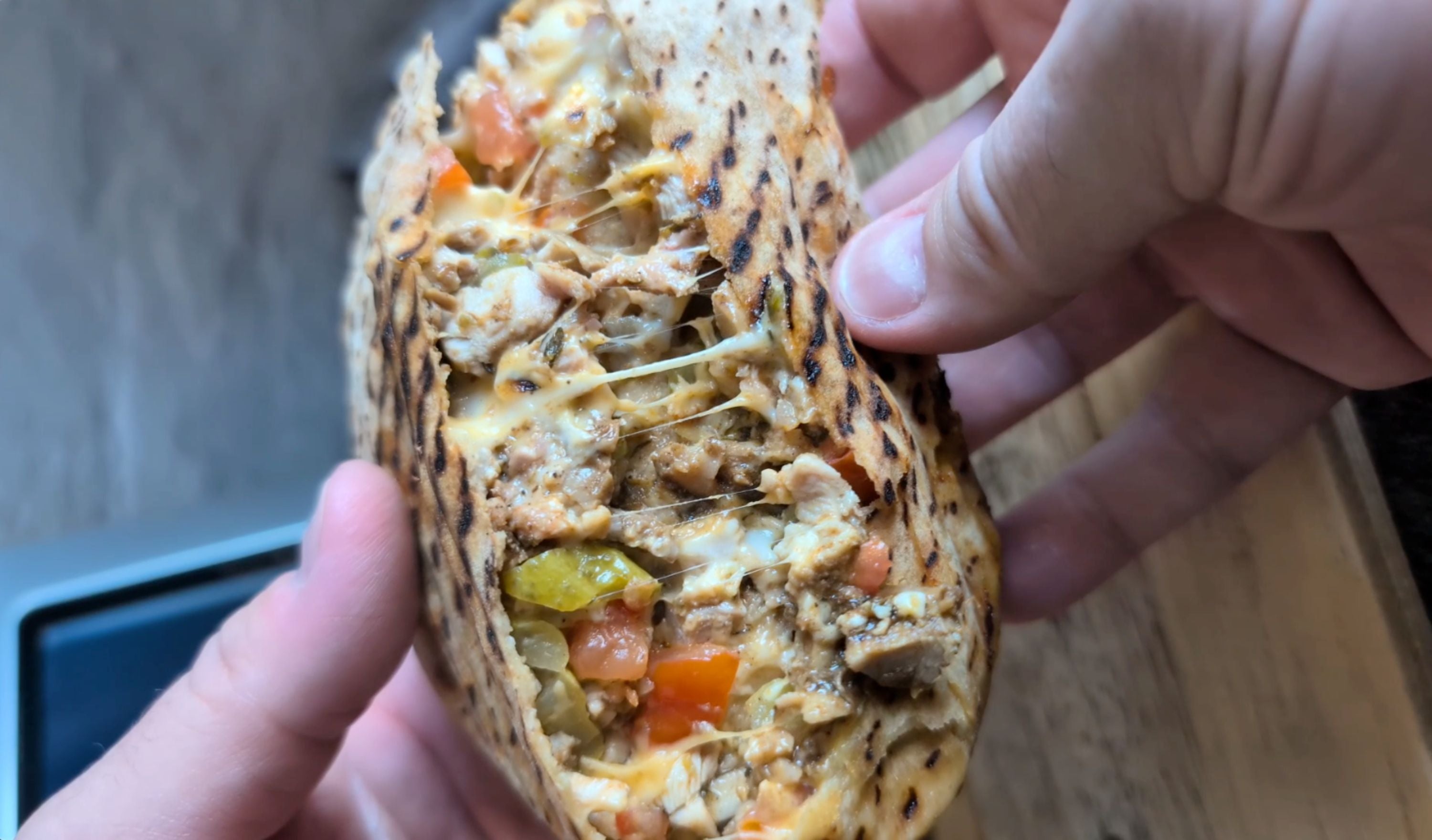Toasted shawarma pocket filled with spiced chicken, melted cheese, pickles, and tomato, drizzled with creamy tzatziki sauce.
