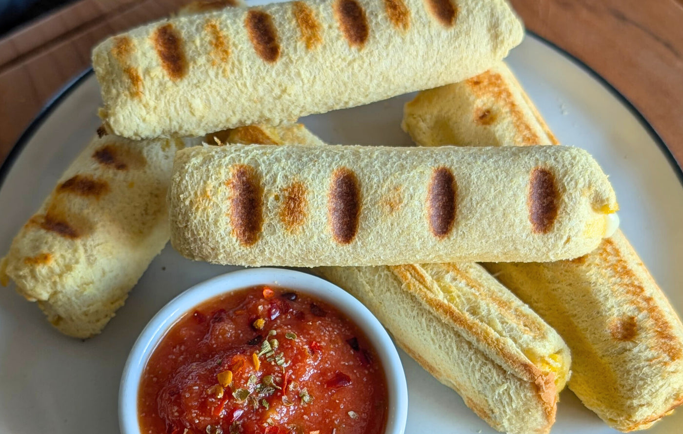 Crispy no-fryer mozzarella sticks made with bread and melted cheese served with marinara sauce