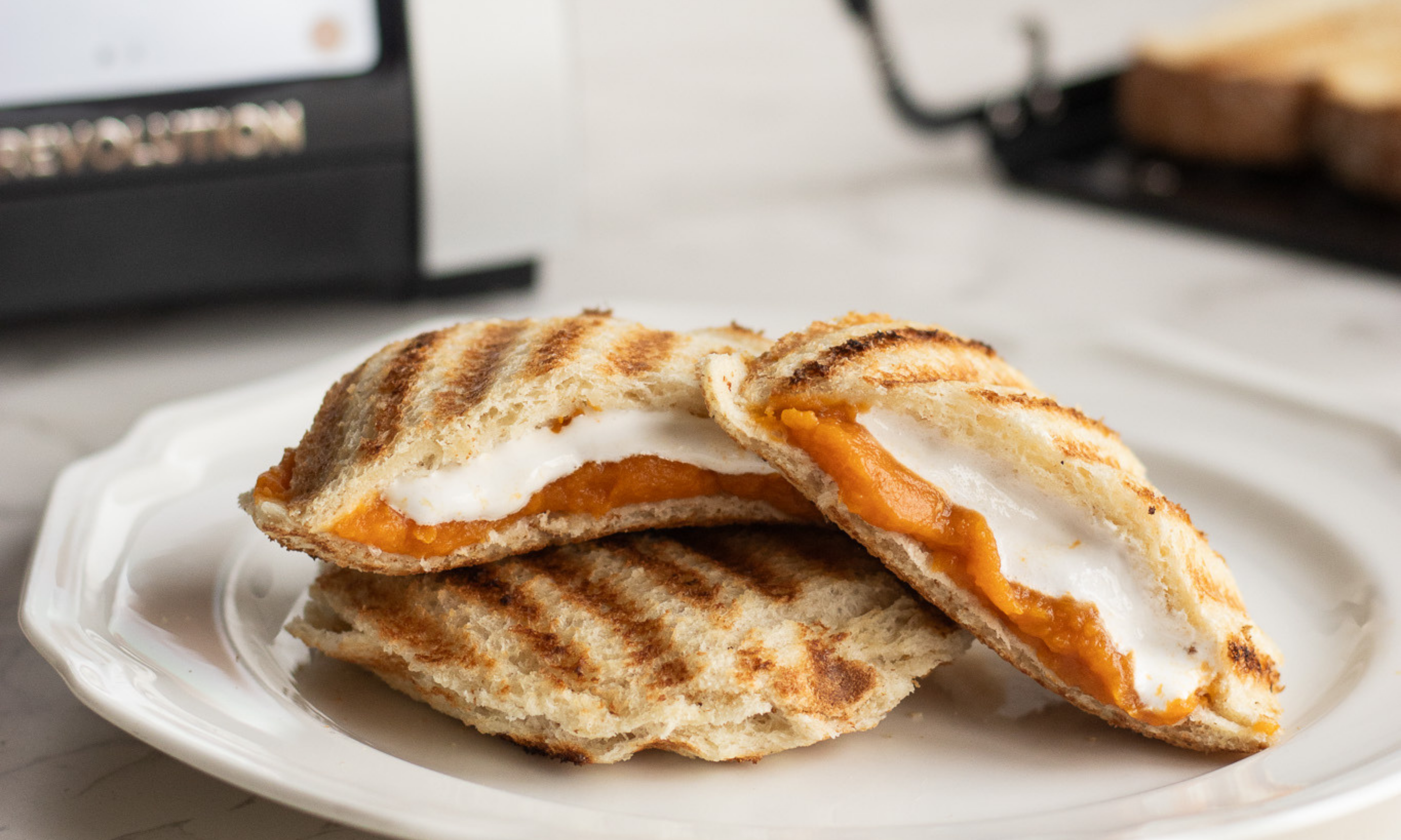 Close-up of a Sweet Potato Marshmallow Uncrustable being pulled apart, showing the melted marshmallow center.