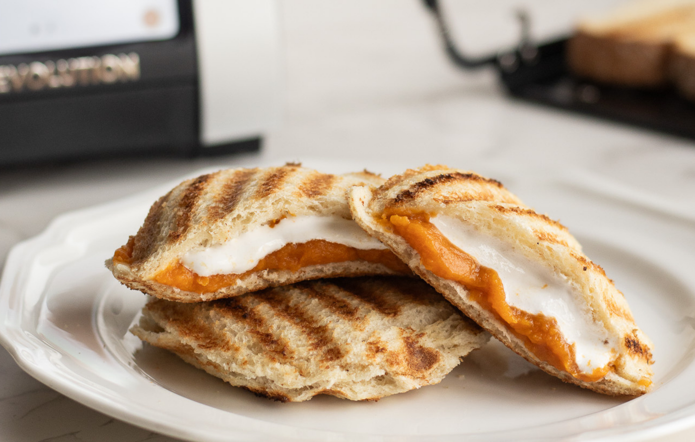 Close-up of a Sweet Potato Marshmallow Uncrustable being pulled apart, showing the melted marshmallow center.