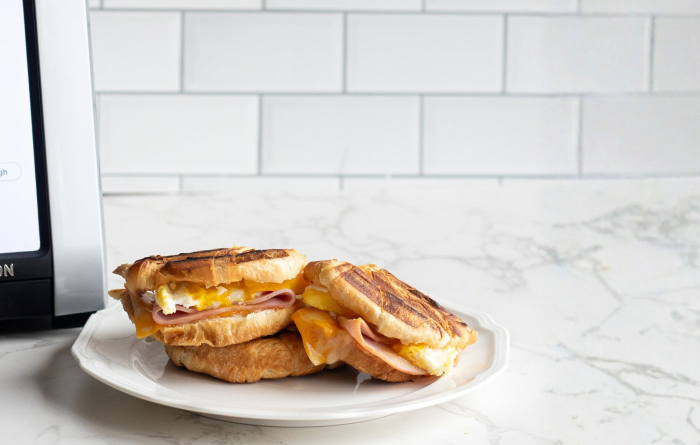 Croissant toastie breakfast sandwich pressed in the toastie press with ham, egg and cheese.