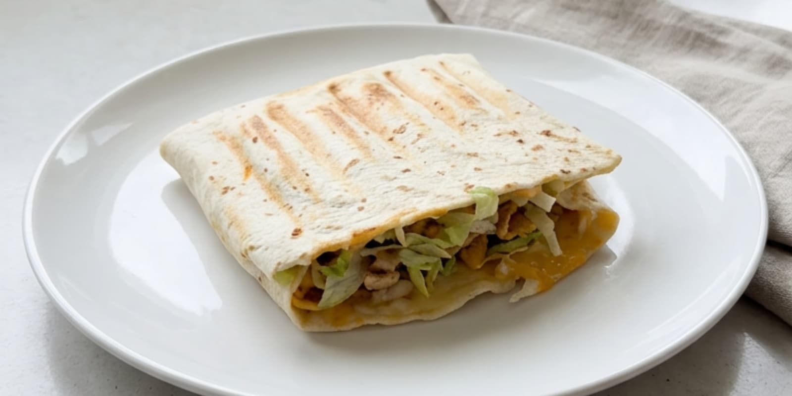 Toaster walking taco melt with seasoned taco meat, melted cheese, crunchy Fritos, lettuce, salsa, and chipotle ranch in crispy toasted bread