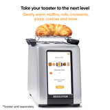 Revolution InstaGLO R270 on a white background with the warming rack and croissant on top. Screen on warming rack mode. Text says "Take your toaster to the next level. Gently warm muffins, rolls, croissants, pizza, coolies, and more. toaster sold separately" 