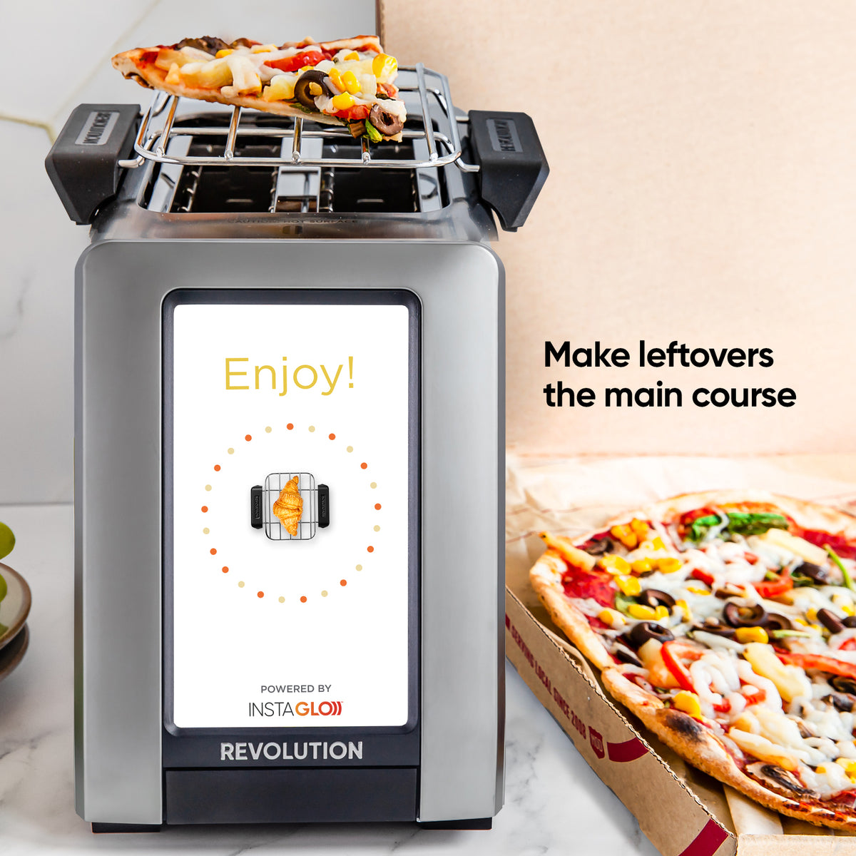 Revolution R270 on the enjoy screen with the warming rack on top with a slice of pizza. box of pizza sitting next to it.